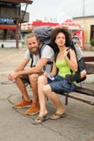 A couple of backpacker tourists sitting on a bench Royalty Free Stock Photo A couple of backpacker tourists sitting on a bench Royalty Free Stock Photo