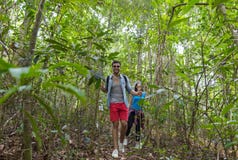 Couple With Backpacks Trekking On Forest Path, Young Man And Woman Holding Hands Walk On Hike Tourists stock photo Couple With Backpacks Trekking On Forest Path, Young Man And Woman Holding Hands Walk On Hike Tourists stock photo