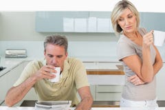 Couple with coffee cups reading newspaper in kitchen Royalty Free Stock Image Couple with coffee cups reading newspaper in kitchen Royalty Free Stock Image