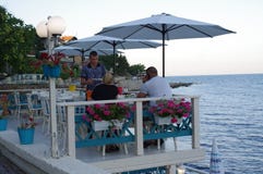Couple enjoy an evening at a restaurant by a sea royalty free stock photos Couple enjoy an evening at a restaurant by a sea royalty free stock photos