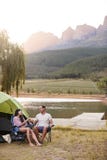 Couple Enjoying Camping Vacation By Lake Making A Toast royalty free stock photo Couple Enjoying Camping Vacation By Lake Making A Toast royalty free stock photo