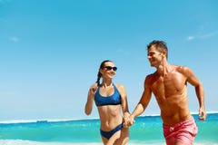 Couple Fun On Beach. Romantic People In Love Running At Sea royalty free stock image Couple Fun On Beach. Romantic People In Love Running At Sea royalty free stock image