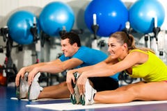 Couple in gym stretching
