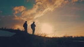 Couple hiking help each other silhouette in mountains. Teamwork couple hiking, help each other, trust assistance, sunset stock footage Couple hiking help each other silhouette in mountains. Teamwork couple hiking, help each other, trust assistance, sunset stock footage
