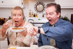 Couple In Kitchen Late For Work Royalty Free Stock Image