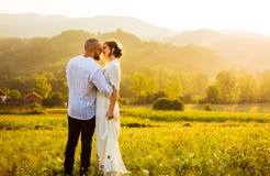 Couple kissing during a romantic sunset stock photo Couple kissing during a romantic sunset stock photo