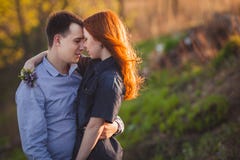 Couple kissing standing outdoos among bushes. Young couple kissing standing outdoos among bushes Stock Photography Couple kissing standing outdoos among bushes. Young couple kissing standing outdoos among bushes Stock Photography