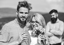Couple in love dating while jealous bearded man watching wife cheating him with lover. Infidelity concept. Lovers hugs stock photo Couple in love dating while jealous bearded man watching wife cheating him with lover. Infidelity concept. Lovers hugs stock photo