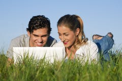 Couple on meadow using wi-fi for Internet stock image Couple on meadow using wi-fi for Internet stock image