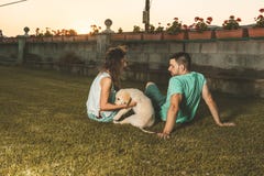 Couple with a puppy dog in the countryside. Man and woman with their adorable puppy in a sunset. royalty free stock photo Couple with a puppy dog in the countryside. Man and woman with their adorable puppy in a sunset. royalty free stock photo