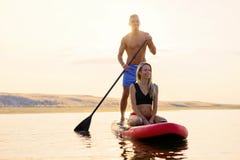 Couple relaxing together on paddle board stock photos Couple relaxing together on paddle board stock photos