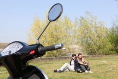 Couple sat near scooter stock photography Couple sat near scooter stock photography