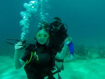 A couple scuba dive together. stock photo A couple scuba dive together. stock photo