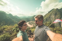 Couple selfie on mountain top at Nong Khiaw panoramic view over Nam Ou River valley Laos travel destination in South East Asia, stock photo Couple selfie on mountain top at Nong Khiaw panoramic view over Nam Ou River valley Laos travel destination in South East Asia, stock photo