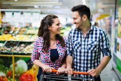 Couple shopping in supermarket while carrying shopping cart stock photo Couple shopping in supermarket while carrying shopping cart stock photo