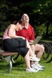 Couple Sitting And Laughing At The Park - Vertical Royalty Free Stock Image