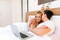 Couple surfing the web from bed in morning stock photography Couple surfing the web from bed in morning stock photography
