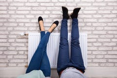 Couple Warming Up Their Feet On Radiator stock photo Couple Warming Up Their Feet On Radiator stock photo