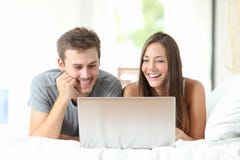 Couple watching videos on a laptop at home stock photos Couple watching videos on a laptop at home stock photos