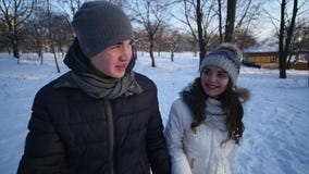 Couple Winter Snow Forest Walking Young Man And Woman Holding Hands In Snowy Park and young woman is offended stock footage Couple Winter Snow Forest Walking Young Man And Woman Holding Hands In Snowy Park and young woman is offended stock footage