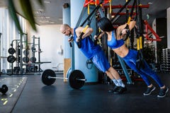 Sporty couple workout in the gym, doing exercise with functional loops. royalty free stock photos Sporty couple workout in the gym, doing exercise with functional loops. royalty free stock photos