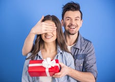 https://thumbs.dreamstime.com/t/couple-young-men-covering-eyes-his-girlfriend-giving-her-present-blue-background-51387236.jpg
