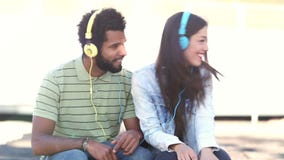 Couples attrayants ayant l'amusement écoutant la musique avec des écouteurs banque de vidéos Couples attrayants ayant l'amusement écoutant la musique avec des écouteurs banque de vidéos