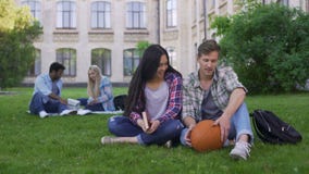 Couples d'étudiant se reposant sur l'herbe près de l'université, parlant et souriant, première passion banque de vidéos Couples d'étudiant se reposant sur l'herbe près de l'université, parlant et souriant, première passion banque de vidéos