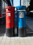 Couples de boîte aux lettres bleus et rouges sur la rue image stock Couples de boîte aux lettres bleus et rouges sur la rue image stock