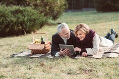 Couples de sourire utilisant le comprimé numérique photographie stock libre de droits Couples de sourire utilisant le comprimé numérique photographie stock libre de droits