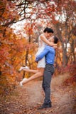 Couples de sourire étreignant en parc d'automne Jeunes mariés heureux dans la forêt, dehors Image libre de droits Couples de sourire étreignant en parc d'automne Jeunes mariés heureux dans la forêt, dehors Image libre de droits