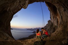 Couples des grimpeurs de roche se reposant en caverne photos libres de droits Couples des grimpeurs de roche se reposant en caverne photos libres de droits