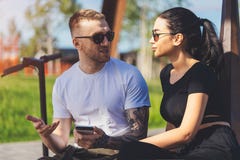 Couples du jeune homme et de la femme s'asseyant en parc sur le banc en bois photo libre de droits Couples du jeune homme et de la femme s'asseyant en parc sur le banc en bois photo libre de droits