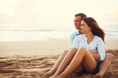 Couples détendant sur la plage observant le coucher du soleil photo libre de droits Couples détendant sur la plage observant le coucher du soleil photo libre de droits