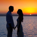 Couples en silhouette d'amour au coucher du soleil de lac Couples en silhouette d'amour au coucher du soleil de lac