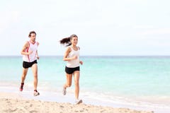 Couples fonctionnant sur la plage images stock Couples fonctionnant sur la plage images stock