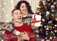 Couples heureux ayant l'amusement dans la décoration de Noël à la maison Soirée du Nouveau an, arbre de sapin ornated Vacances d' Photo libre de droits Couples heureux ayant l'amusement dans la décoration de Noël à la maison Soirée du Nouveau an, arbre de sapin ornated Vacances d' Photo libre de droits