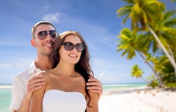 Couples heureux dans des lunettes de soleil au-dessus de plage tropicale photographie stock Couples heureux dans des lunettes de soleil au-dessus de plage tropicale photographie stock