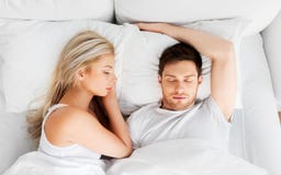 Couples heureux dormant dans le lit à la maison photo libre de droits Couples heureux dormant dans le lit à la maison photo libre de droits