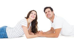 Couples heureux se trouvant sur le plancher recherchant photographie stock Couples heureux se trouvant sur le plancher recherchant photographie stock
