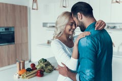 Couples heureux étreignant dans la cuisine Relations romantiques photos stock Couples heureux étreignant dans la cuisine Relations romantiques photos stock