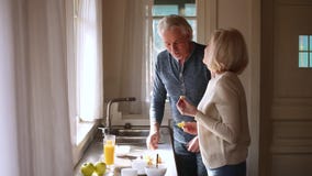 Couples mûrs supérieurs affectueux heureux ayant l'amusement préparant le petit déjeuner sain banque de vidéos Couples mûrs supérieurs affectueux heureux ayant l'amusement préparant le petit déjeuner sain banque de vidéos