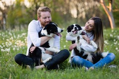 Couples romantiques chez les chiens de marche d'amour dans la nature et le sourire photographie stock libre de droits Couples romantiques chez les chiens de marche d'amour dans la nature et le sourire photographie stock libre de droits