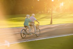 Couples supérieurs montant la bicyclette tandem photo stock Couples supérieurs montant la bicyclette tandem photo stock