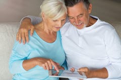 Couples supérieurs utilisant le comprimé numérique photos libres de droits Couples supérieurs utilisant le comprimé numérique photos libres de droits