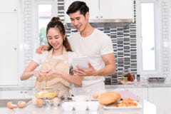 Couplez faire la boulangerie, le gâteau dans la chambre de cuisine, le jeune homme asiatique et la femme photos libres de droits Couplez faire la boulangerie, le gâteau dans la chambre de cuisine, le jeune homme asiatique et la femme photos libres de droits