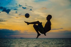 Coups de pied d'une boule Silhouette d'un homme sur une plage image stock Coups de pied d'une boule Silhouette d'un homme sur une plage image stock