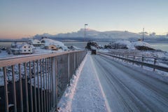 Course glissante de route neigeuse à travers le pont dans des îles de Lofoten, Norvège images stock Course glissante de route neigeuse à travers le pont dans des îles de Lofoten, Norvège images stock