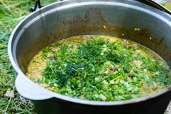 Cous cous för läcker havregröt med kött, grönsaker och nya örter i en krukamatlagning på naturen arkivfoton Cous cous för läcker havregröt med kött, grönsaker och nya örter i en krukamatlagning på naturen arkivfoton