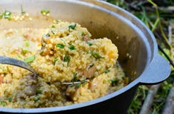 Cous cous för läcker havregröt med kött, grönsaker och nya örter i en krukamatlagning på naturen royaltyfri bild Cous cous för läcker havregröt med kött, grönsaker och nya örter i en krukamatlagning på naturen royaltyfri bild